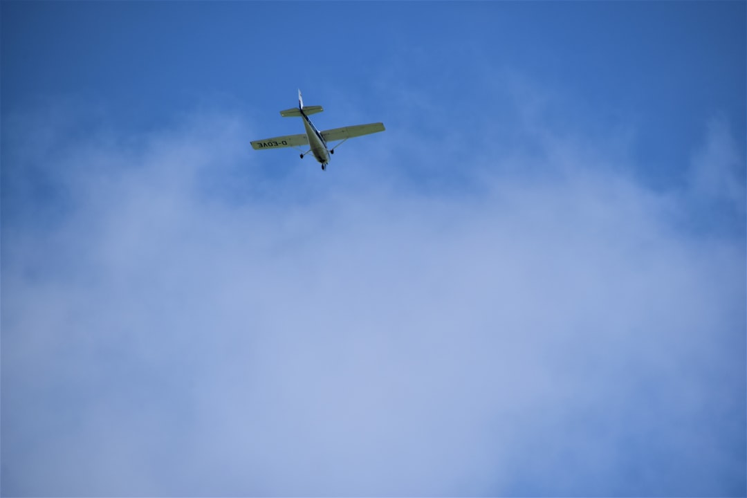 white airplane in mid air during daytime